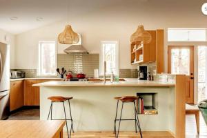 una cocina con una isla grande con 2 taburetes en VACATION Mod Cottage Idyllic Setting Every Amenity, en Rosendale
