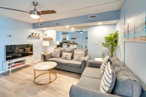 a living room with a couch and a tv at Cozy Coastal Condo with Airy Oceanfront Balcony in Myrtle Beach