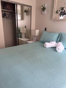 Un dormitorio con una cama verde con toallas. en Cozy & Relax Airb&b LLC, en Brooklyn