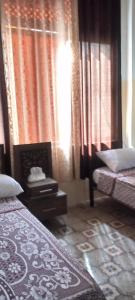 1 Schlafzimmer mit 2 Betten und Vorhängen sowie einem Fenster in der Unterkunft Jawal Hotel in Amman