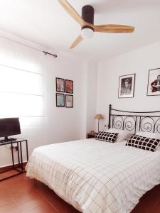 - une chambre avec un lit et un ventilateur de plafond dans l'établissement VERALID Gran terraza, Wi Fi y AC en Puerto Rey, à Vera