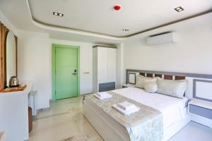 a bedroom with a large bed and a green door at Stonehillkaş in Kas