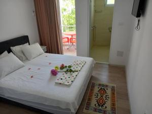 a bedroom with a white bed with flowers on it at Apartments Verona in Ulcinj