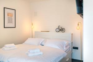 um quarto com uma cama branca e toalhas em CITY BREAK Studio apartments em Sibenik