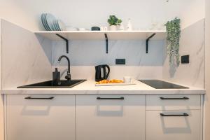 een keuken met witte kasten en een wastafel bij CITY BREAK Studio apartments in Šibenik