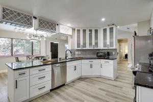 a large kitchen with white cabinets and a refrigerator at Bedford Retreat with Private Pool and Gas Grill! in Bedford