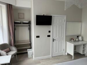 Habitación con puerta y TV en la pared en Marques Sands Hotel en Bournemouth