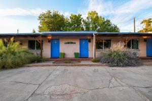 an old building with blue doors in a parking lot at Charming 2 Bedroom Near Downtown - Rose Tree 1 in Moab