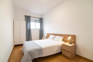 1 dormitorio con cama y mesita de noche con lámpara en Livramento Residence, en Livramento