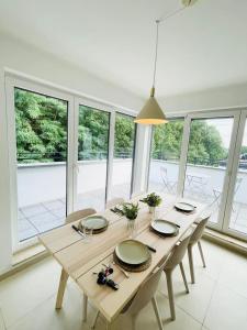 una mesa de madera en una habitación con ventanas en Luxury Green Penthouse Terrace&Parking - 117 en Luxemburgo