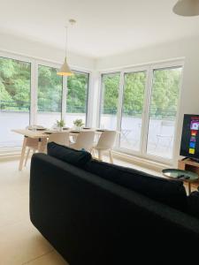 ein Wohnzimmer mit einem Sofa, einem Tisch und Stühlen in der Unterkunft Luxury Green Penthouse Terrace&Parking - 117 in Luxemburg (Stadt)