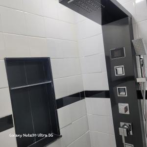 - une douche revêtue de carrelage noir et blanc dans l'établissement Cozy & Relax LLC Airb&b, à Brooklyn