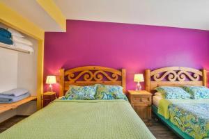 una camera con due letti e una parete viola di Adventure Haven Near Downtown - Rose Tree 3 a Moab
