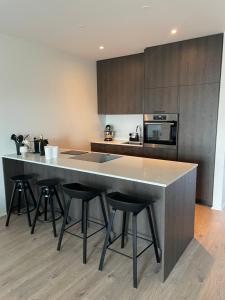 a kitchen with a large island with bar stools at Well located luxury apartment in Njarðvík