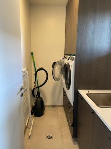 a kitchen with a washing machine and a sink at Well located luxury apartment in Njarðvík