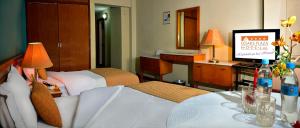 Cesar's Plaza Hotel في كوتشابامبا: غرفه فندقيه سريرين وتلفزيون