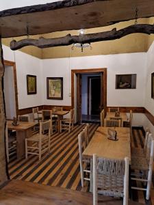 comedor con mesas y sillas de madera en Hotel Artesanos, en Villa Alegre
