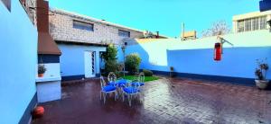 a courtyard with blue and white chairs and a building at CASA CÉNTRICA RIOJA ,Patio Parrilla, Zona Residencial, Parking privado gratis a 100 mts in Mendoza