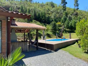 a swimming pool with a pergola next to a house at Sítio pra até 14 pessoas preço único na Serra Catarinense in Annitapolis