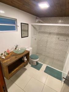 een badkamer met een wastafel, een toilet en een douche bij Recanto da Felicidade para 13 pessoas in Annitapolis