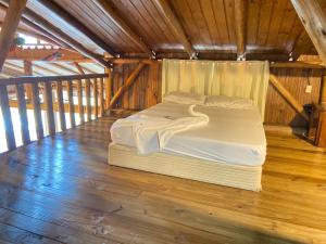 een bed in een kamer met een houten vloer bij Recanto da Felicidade para 13 pessoas in Annitapolis