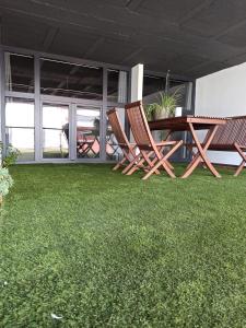 two chairs and a table on a patio with grass at Albergue HR in Sarria