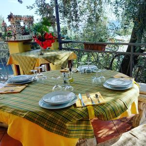 a green and yellow table with plates and glasses on it at Agriturismo Al Nido Degli Aironi in Sanremo
