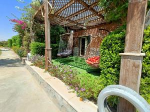 a garden with two hammocks in a pergola at Stella Di Mare - Amazing Two Bedrooms Sea View Chalet - Families only in Ain Sokhna