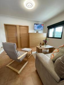 ein Wohnzimmer mit einer Couch und einem Sessel in der Unterkunft LA CASA DE DORA EN LA ESCUSA in Armentera