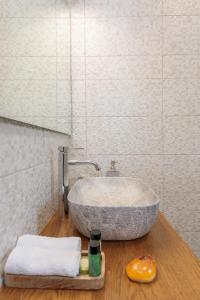 哈爾基的住宿－Bluebell House Halki，一间带石制水槽和镜子的浴室
