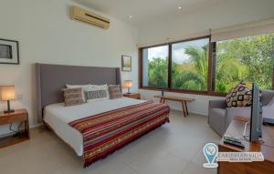 a bedroom with a bed and a large window at Townhome with private Rooftop & Jacuzzi - Beach across street in Akumal +30 photos