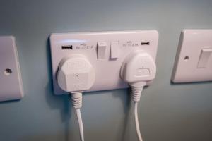 a pair of wii controllers plugged into a wall at Meadow Bank, fabulous apartment in Baddiley