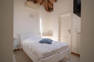 a bedroom with a white bed with a blue pillow on it at Hotel Bellonda in Forte dei Marmi