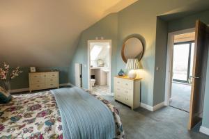 a bedroom with a large bed and a mirror at Meadow Bank, fabulous apartment in Baddiley