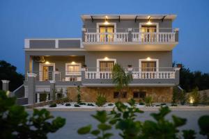 a large white building with a balcony on top of it at Villa Alina in Lefkimmi