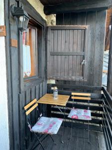 two chairs and a wooden table on a porch at Maison di Viola in Arliod