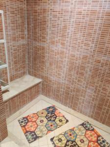 a bathroom with tile walls and two mats on the floor at Lux furnished flat Enjoy ur stay in Nouaceur