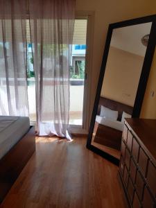 a mirror in a bedroom with a bed and a couch at Lux furnished flat Enjoy ur stay in Nouaceur