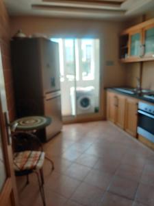 a kitchen with a refrigerator and a table in it at Lux furnished flat Enjoy ur stay in Nouaceur