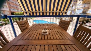 Una mesa de madera con una planta en un balcón. en Mediterraneo, en Santa Pola