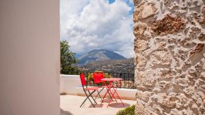 two chairs and a table on a balcony with a mountain at Mitato Eagle's Nest Asfentamos in Níthavris