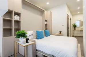 a bedroom with a large white bed with blue pillows at City Life Bliss Central Studio in Reading CHRL F3 in Reading