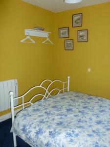 a bedroom with a bed and a yellow wall at The Coach House, Hesket Newmarket in Hesket Newmarket
