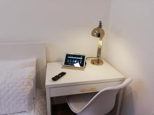 einen Schreibtisch mit Laptop neben einem Bett in der Unterkunft Buddies Charm House in Aveiro