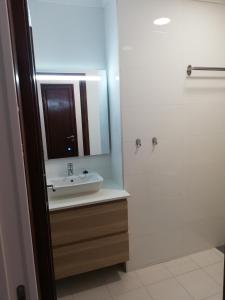 ein Bad mit einem Waschbecken und einem Spiegel in der Unterkunft Buddies Charm House in Aveiro