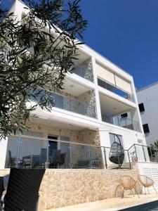 Apartment mit Balkon und Stühlen in der Unterkunft Apartments Kovacev in Zadar