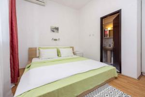 a bedroom with a large bed with white and green sheets at Apartment in Selce 5803 in Selce