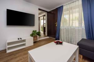 a living room with a white table and a flat screen tv at Apartment in Selce 5803 in Selce