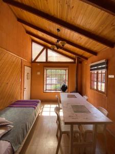 a bedroom with a bed and a table with chairs at Cabañas Doña Juanita in San Pedro de Atacama