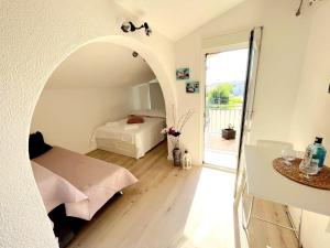 a bedroom with a bed and a door to a balcony at Apartments Nela in Podstrana